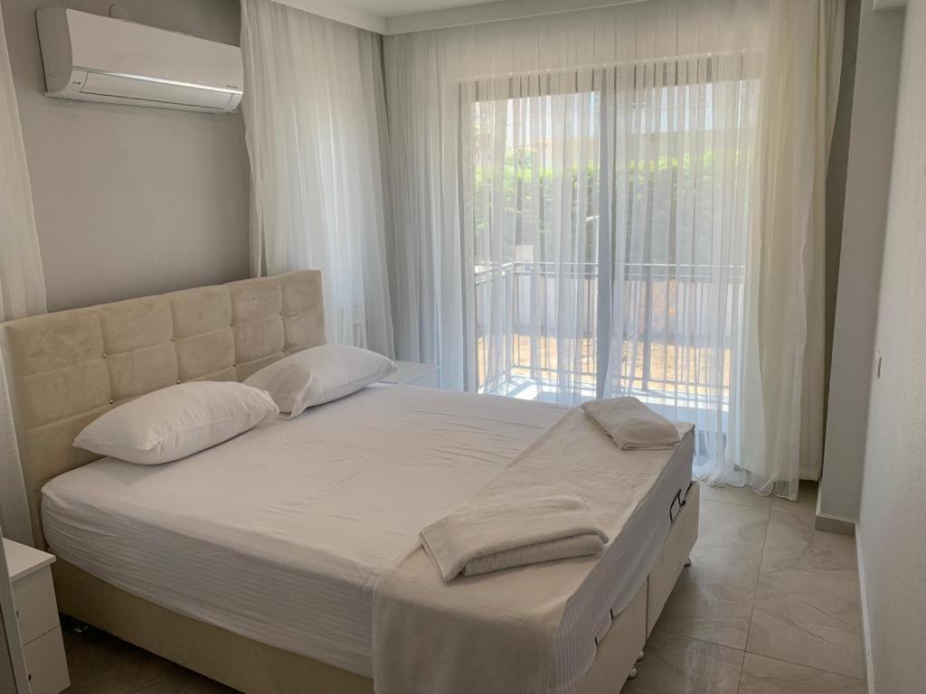 un letto in una camera da letto con una grande finestra di Villa’s Tomris a Ortaca