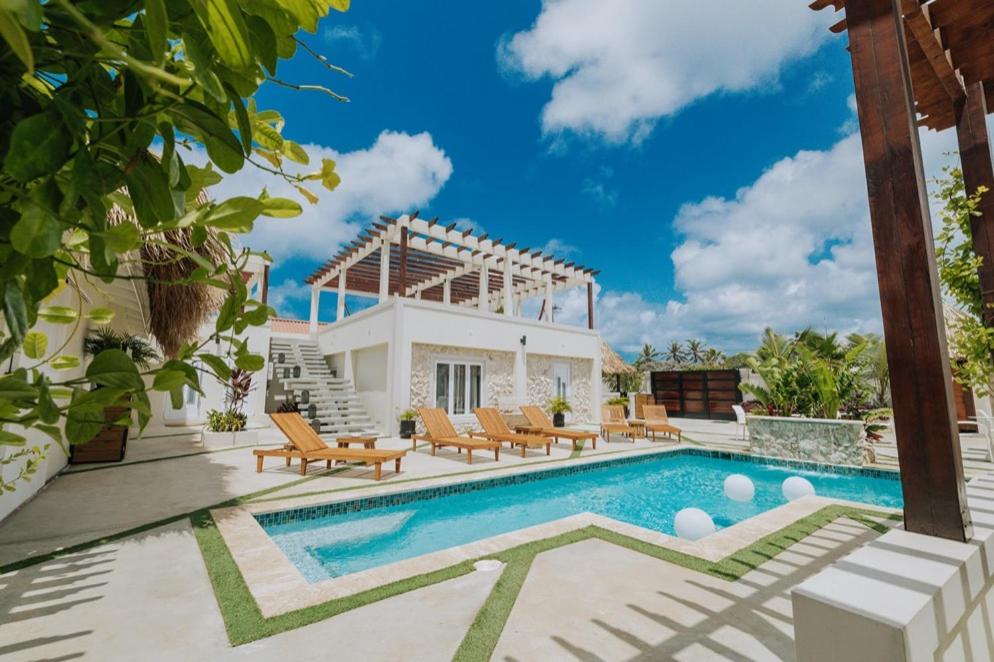 a villa with a swimming pool and a house at EVA Resort in Savaneta