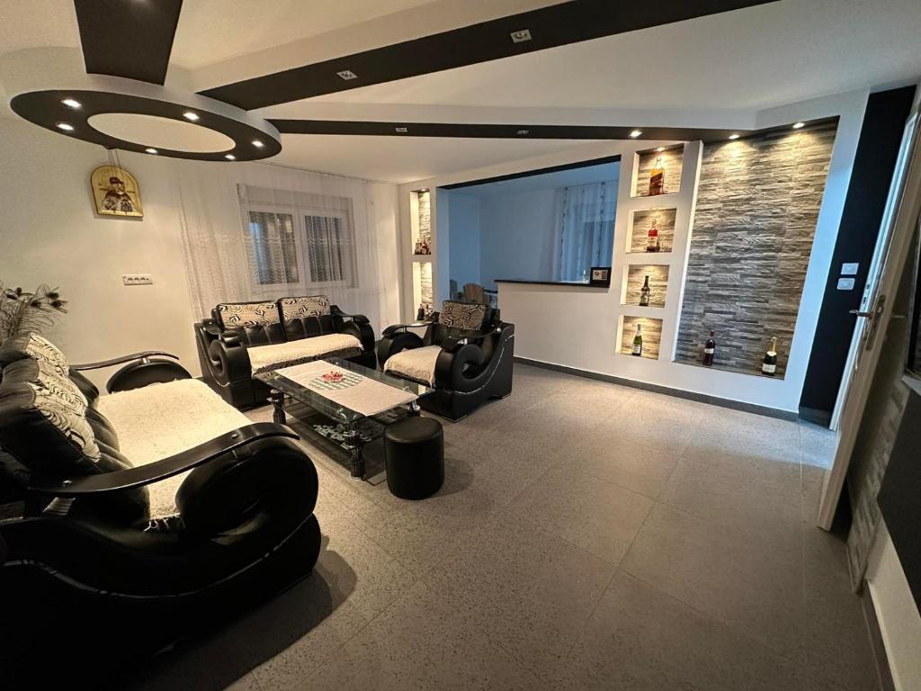 a living room with black furniture and a large window at ANGELIKATOS in Golubac