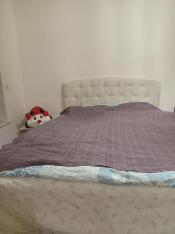 a bed with a purple comforter and a stuffed animal at Family house in Ankara