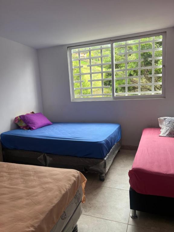 Zimmer mit 2 Betten und einem Fenster in der Unterkunft Finca entre nubes in Guarne