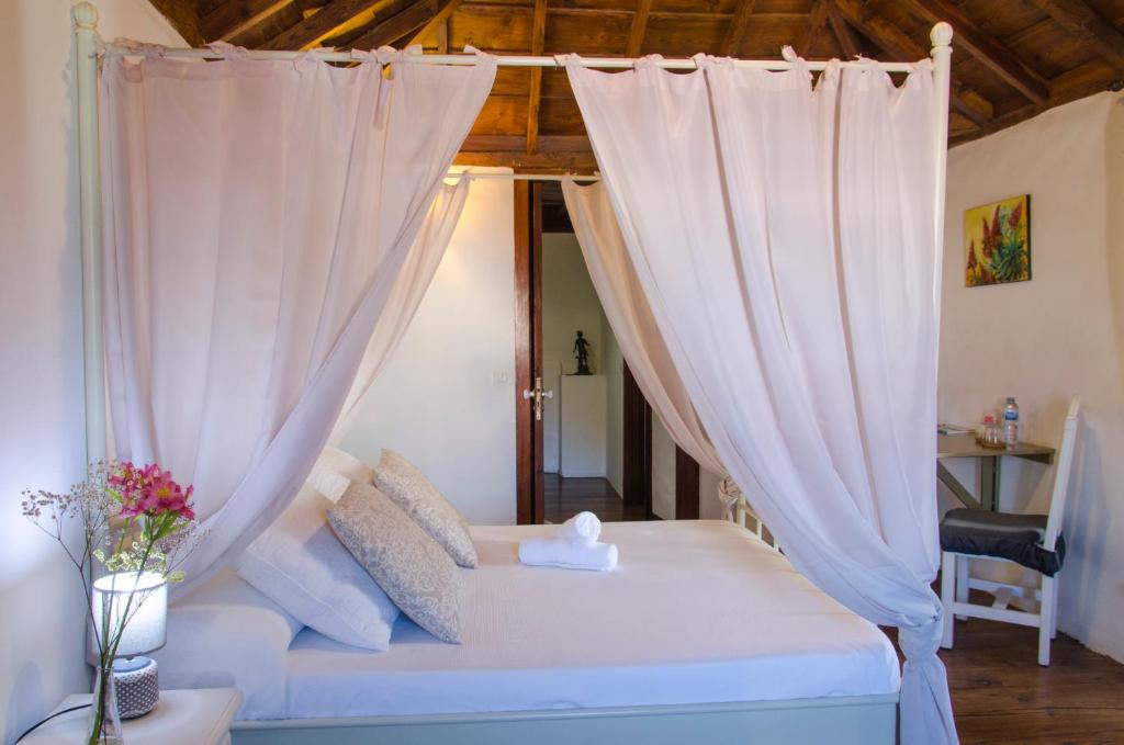 Hotel rural casona Santo Domingo في غيمار: سرير مع ستائر بيضاء في الغرفة