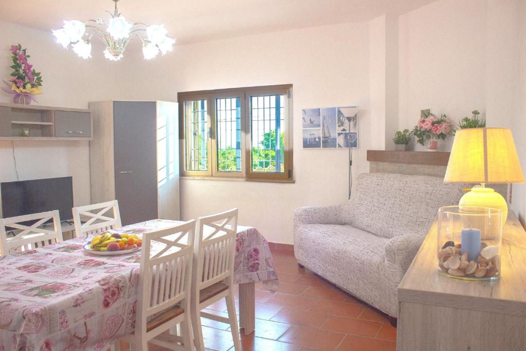 ein Wohnzimmer mit einem Tisch und ein Wohnzimmer mit einem Sofa in der Unterkunft Sardinia SeaBreeze Villa IUN R2178 in Castelsardo