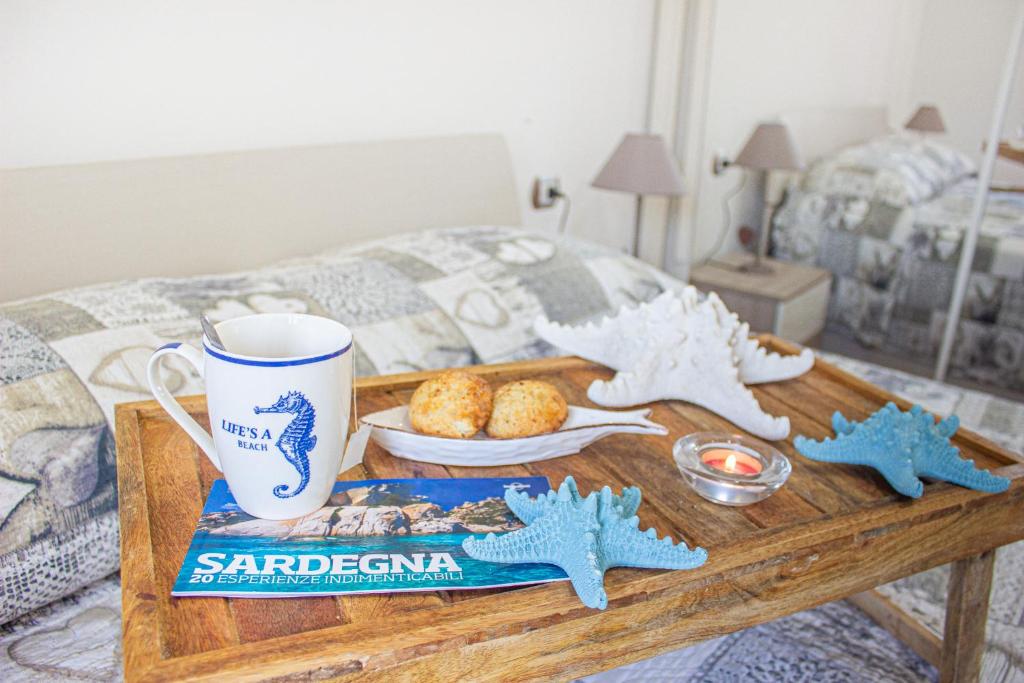 a table with a coffee mug and cookies on a bed at Sardinia SeaBreeze Villa IUN R2178 in Castelsardo