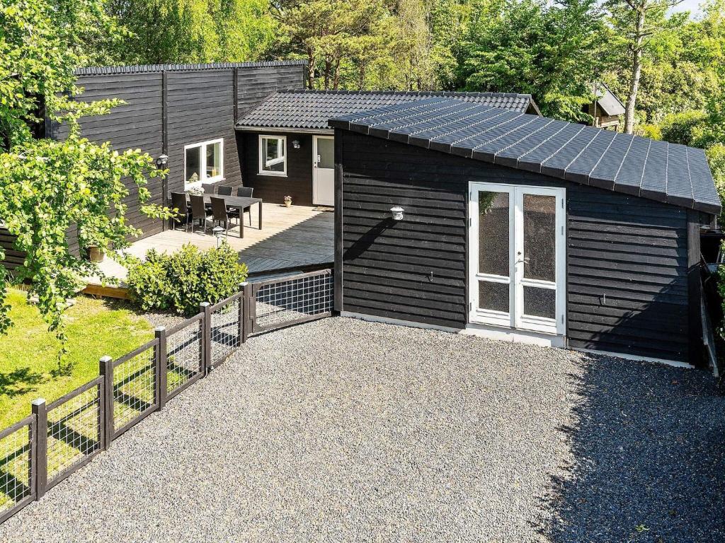 um barracão preto com um alpendre e um pátio em Holiday home Slagelse XVIII em Slagelse