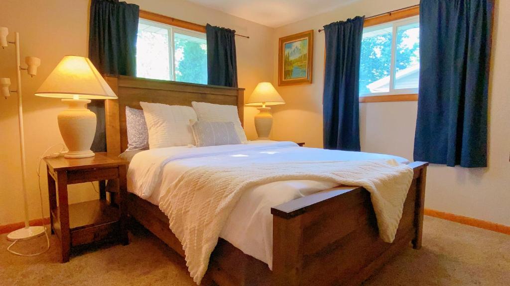 a bedroom with a large bed with blue curtains at Fantastic Oasis Home in Stevens Point in Stevens Point