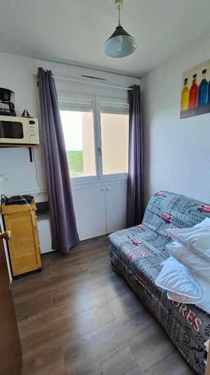- une petite chambre avec un lit et un four micro-ondes dans l'établissement Petite studette à 50m de la plage, à Saint-Jean-de-Monts