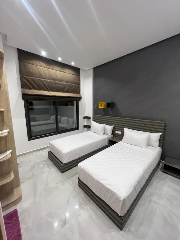- une chambre avec 2 lits et une fenêtre dans l'établissement La Perla Malabata hills, à Tanger