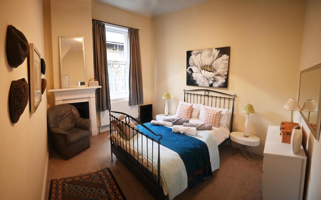 a bedroom with a bed and a chair and a fireplace at Hope House, Hebden's Hidden Gem in Hebden Bridge