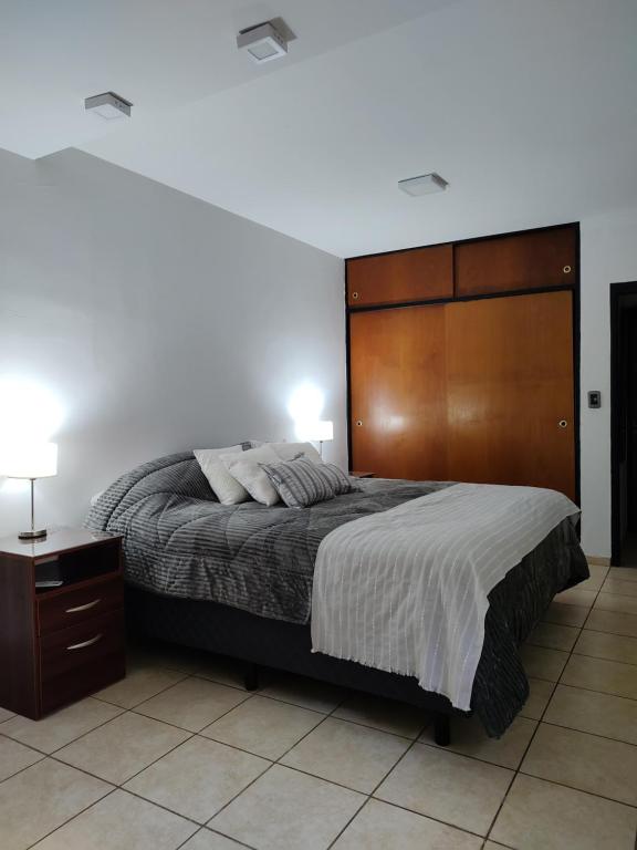 1 dormitorio con 1 cama grande y cabecero de madera en Consorcio España 216 en San Juan