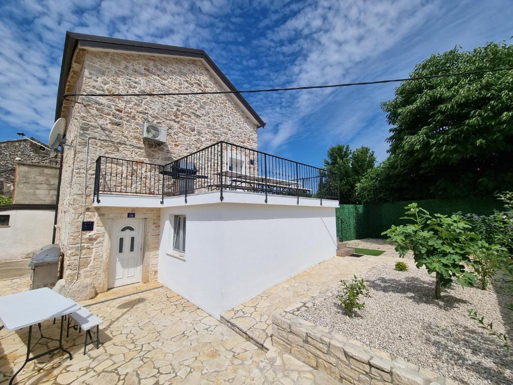 un edificio con un balcón en el lateral. en Istrian APP House MARGARITA en Vilanija