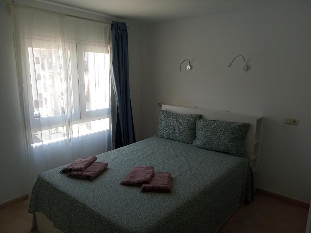 a bedroom with a bed with two towels on it at Casa Katze, 2 dormitorios, céntrica, playa y descanso in Carboneras