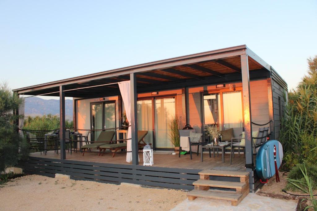 a house with a deck with tables and chairs at Sha-Shaaa Luxury Mobile Home - Terra Park SpiritoS in Kolan