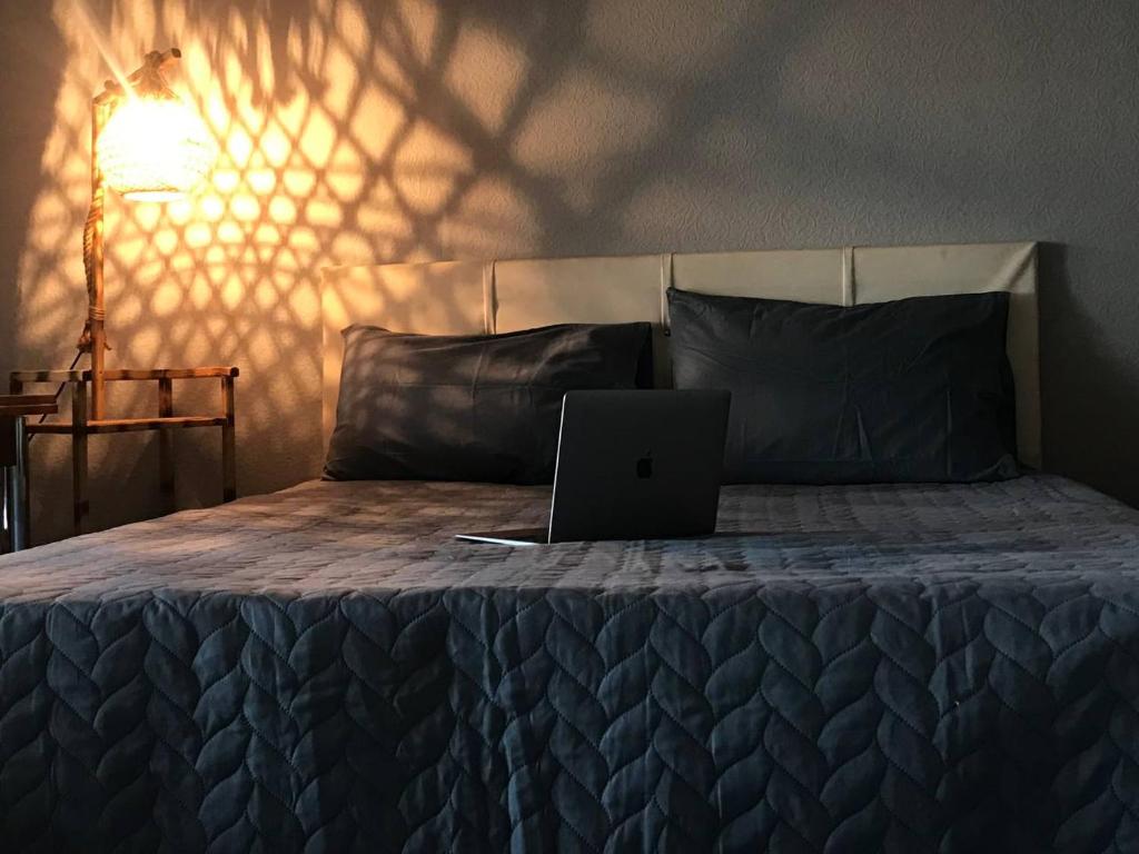 un ordenador portátil sentado en la parte superior de una cama en Cozy Room in Istanbul's Central Uskudar en Estambul