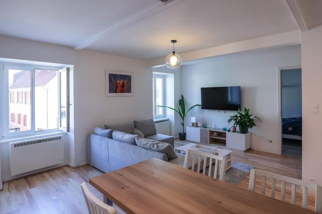 a living room with a blue couch and a table at Appartement centre ville Rixheim in Rixheim