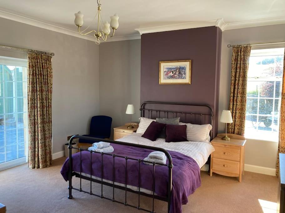 um quarto com uma cama com uma colcha roxa em Polharrow em Dalry