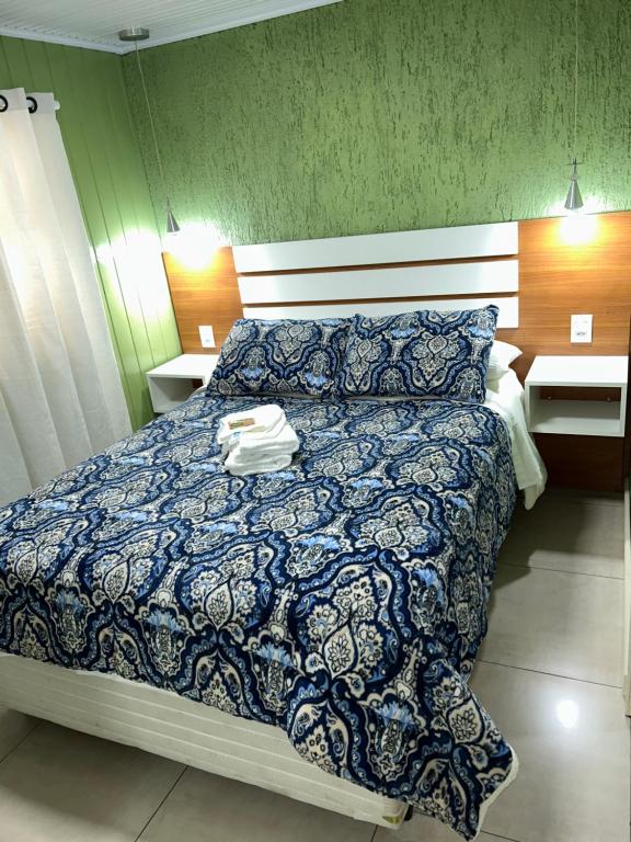 - une chambre avec un lit et une couette bleue dans l'établissement Recanto das Araucárias - Carazal, Gramado., à Gramado