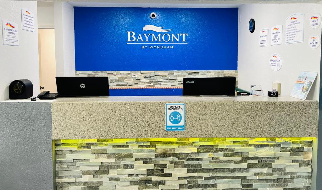 Baymont by Wyndham La Crosse/Onalaska في Onalaska: كونتر استقبال عليه جهازين لابتوب