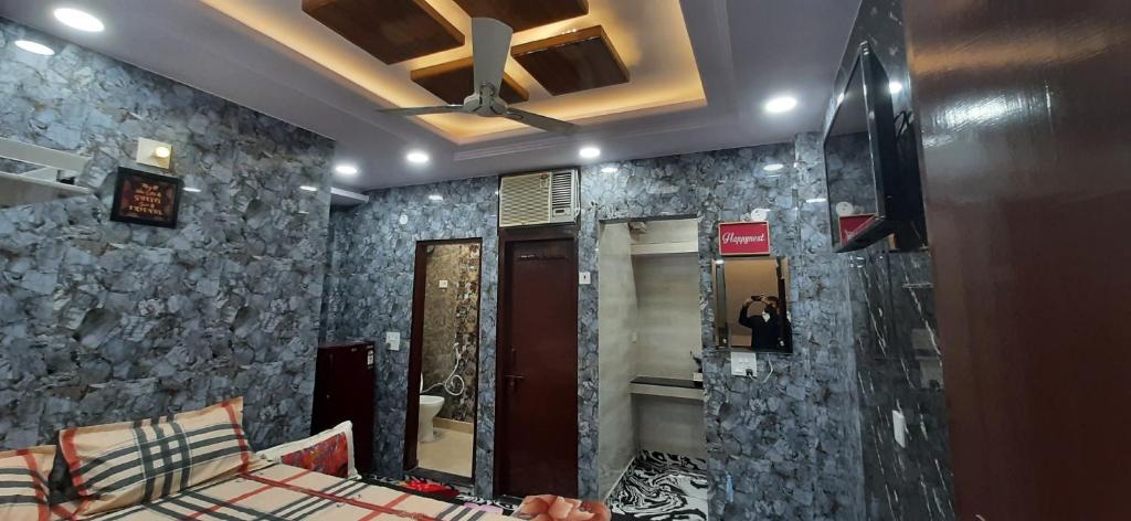 Habitación con espejo grande y pared de piedra. en Aggarwal luxury room with private kitchen washroom and balcony along with fridge, Ac, Android tv, wifi in main lajpat nagar, en Nueva Delhi