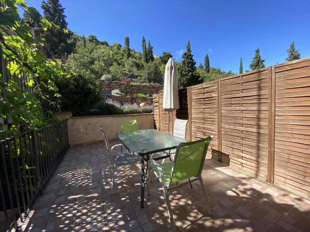 un patio con mesa, sillas y sombrilla en Apartamentos Casa Lola rodeados de montañas y rios, en Beceite