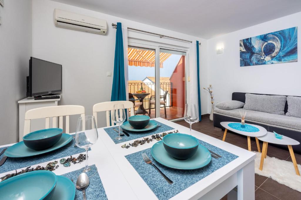 eine Küche und ein Wohnzimmer mit einem Tisch und Stühlen in der Unterkunft Apartment Blue harmony in Dramalj