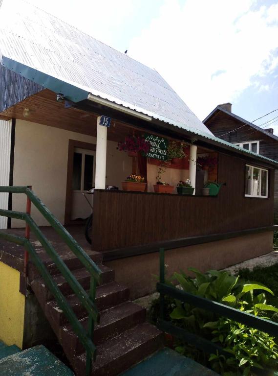 een huis met een groene leuning en een veranda bij Petkovic Guesthouse in Žabljak