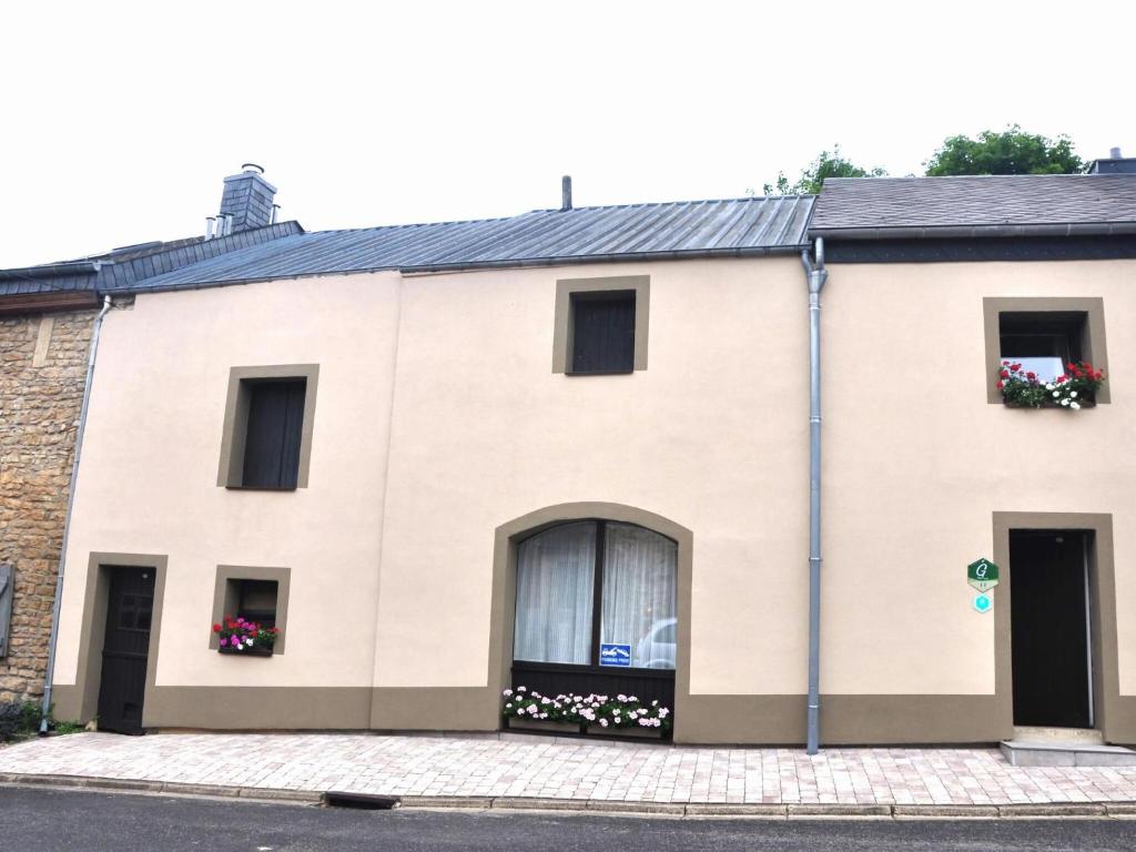 a large white building with windows and flowers in the window boxes at Cozy Cottage in Florenville with garden in Villers-devant-Orval