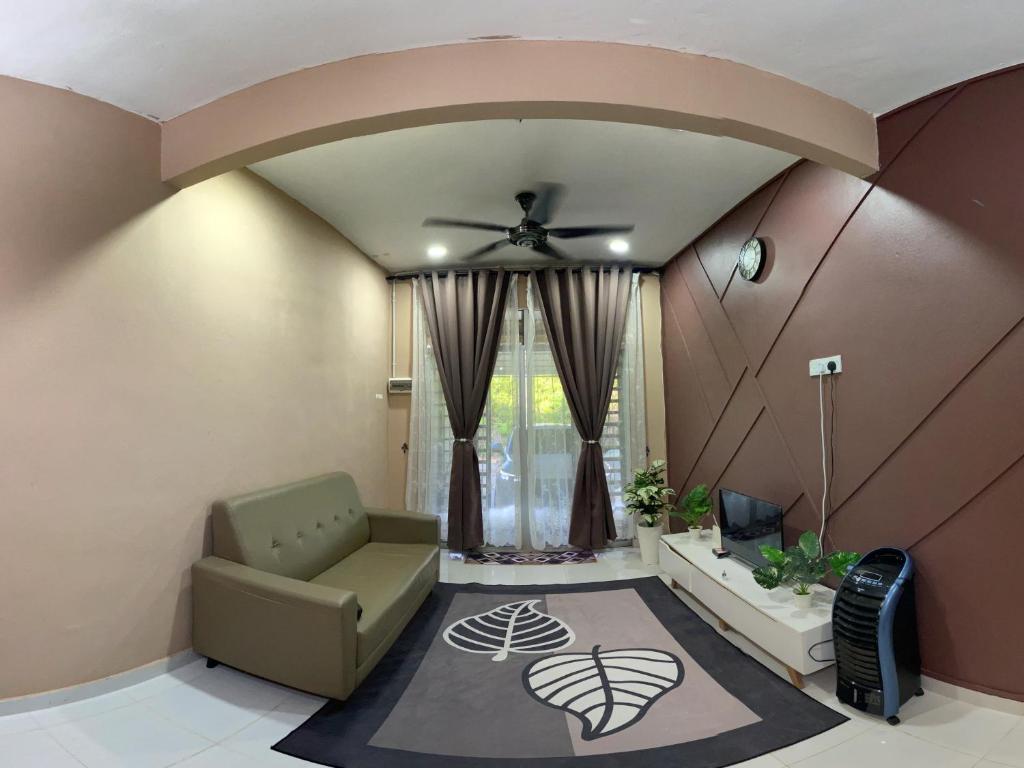 een woonkamer met een plafondventilator en een bank bij Naufa Homestay 2 3R3B Machang in Macang