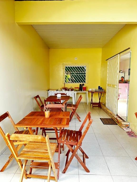 stół i krzesła w pokoju z żółtą ścianą w obiekcie POUSADA E AGENCIA CLEDIO TURISMO w mieście Barreirinhas