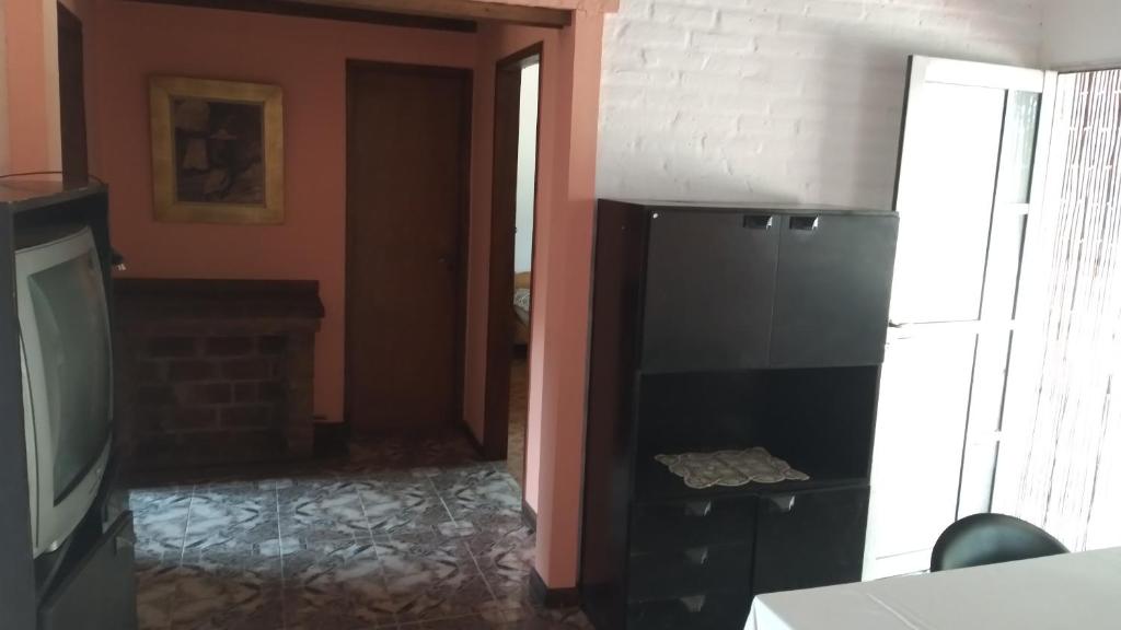 salon z telewizorem i kuchnią w obiekcie Alquiler de casa w mieście Santa Teresita