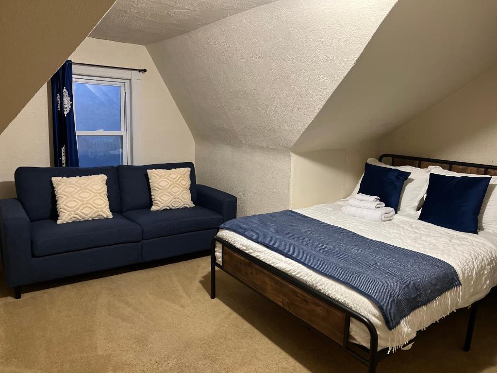 1 dormitorio con 1 cama y 1 sofá azul en Peaceful living, en Hazleton