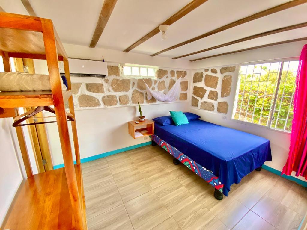 een slaapkamer met een blauw bed en een ladder bij Casa de Orion in Ayangue