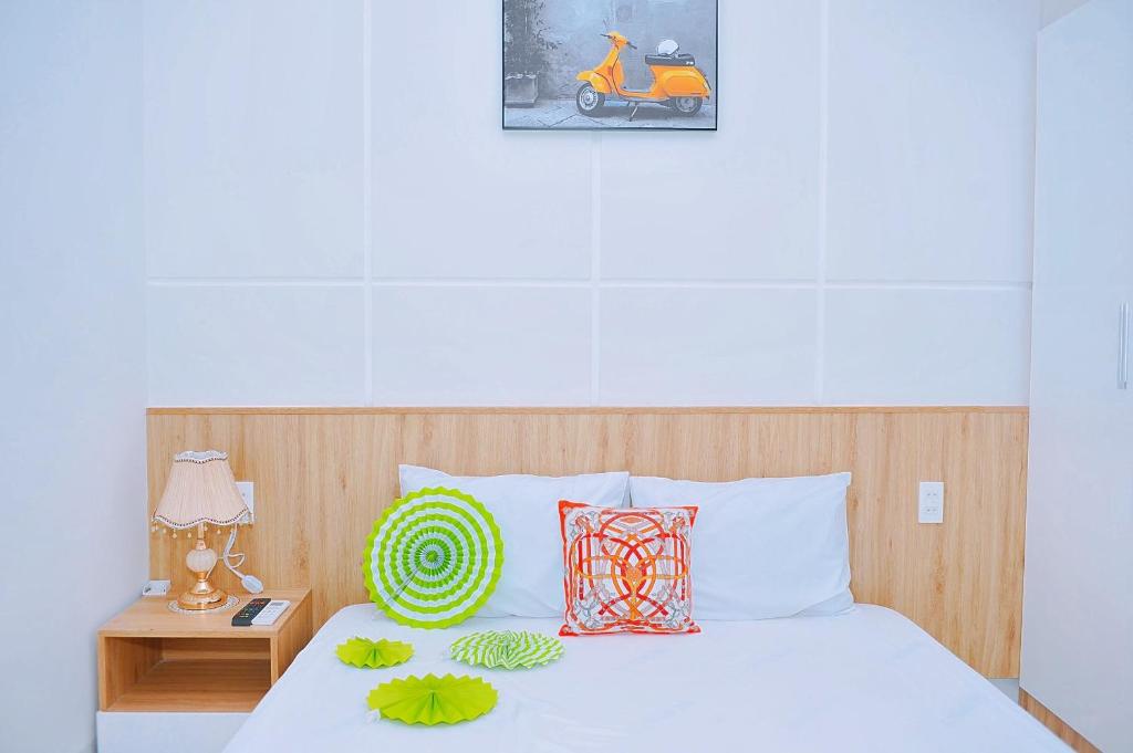 Schlafzimmer mit einem weißen Bett mit einem Kopfteil aus Holz in der Unterkunft Khách Sạn Toàn Yến - Nhơn Lý in Hưng Lương