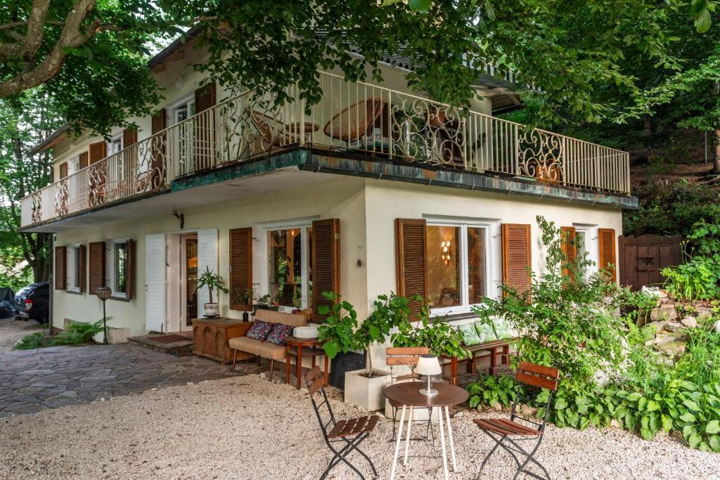 ein Haus mit einem Balkon, einem Tisch und Stühlen in der Unterkunft Gästehaus Wallner in Velden am Wörthersee