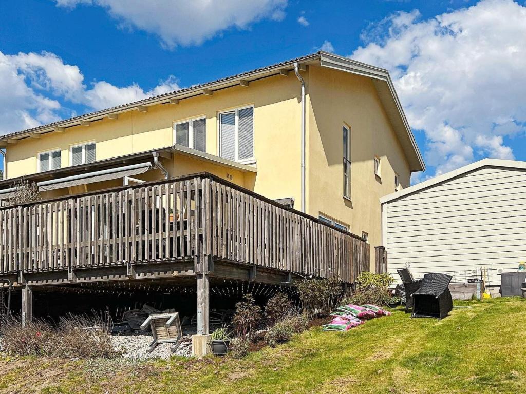 uma casa com um deque de madeira no quintal em Holiday home Sundbyberg em Sundbyberg