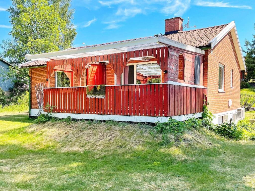 une maison rouge avec une clôture rouge sur une cour dans l'établissement Holiday home BILLINGSFORS II, à Billingsfors