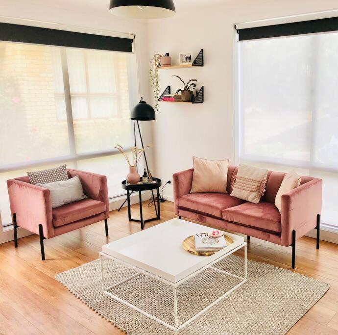 荷伯特的住宿－The Blush House，客厅配有2张粉红色的沙发和咖啡桌