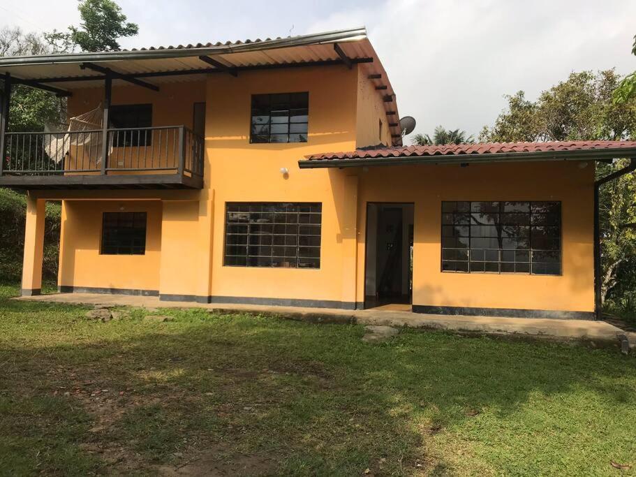 Casa amarilla con balcón y patio en Finca el Mirador oasis de paz en Sasaima