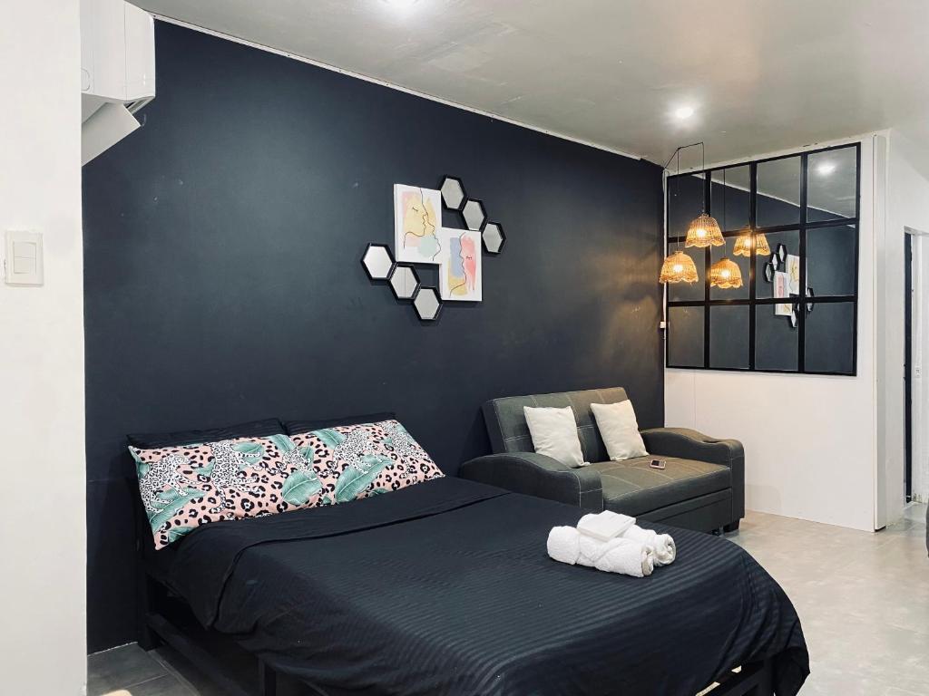 Dormitorio negro con cama y sofá en AKC AirBNB, en Mandaue