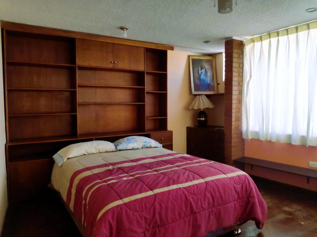 una camera con un grande letto e scaffali in legno di Flying House Hostel ad Arequipa