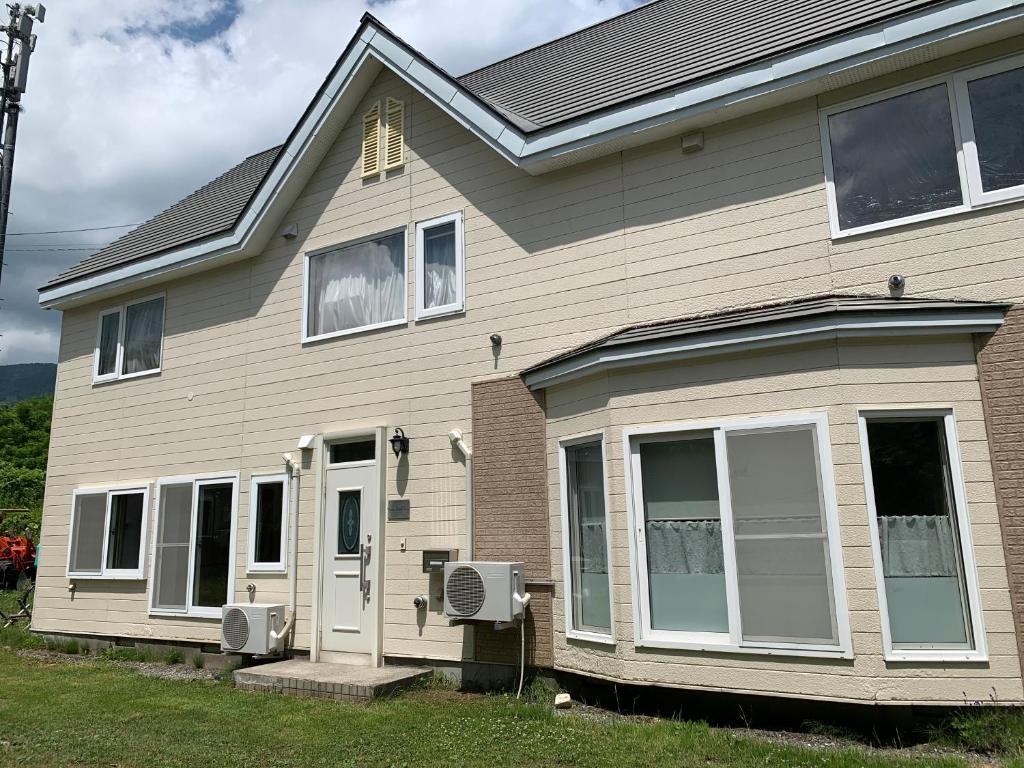 een huis met witte deuren en ramen erop bij Furano Rental House in Furano