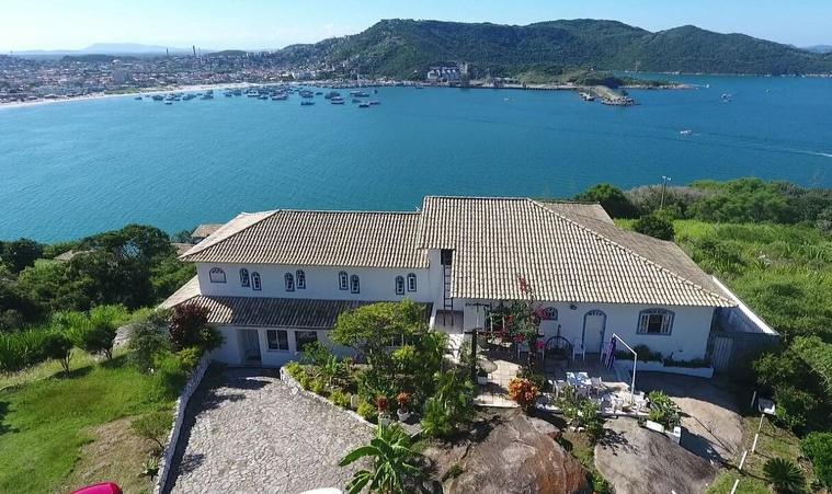 an aerial view of a house on a hill next to the water at Pousada Recanto Marinho in Arraial do Cabo