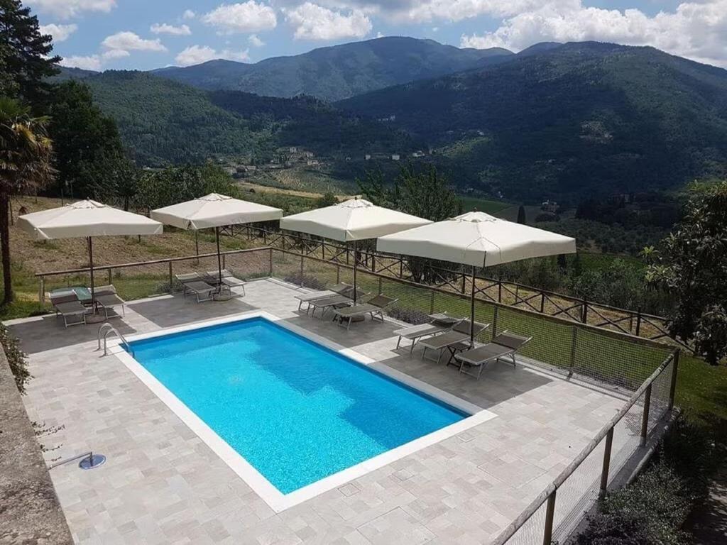 una piscina con sombrillas y sillas en Modern Holiday Home in Pelago with Pool en Donnini