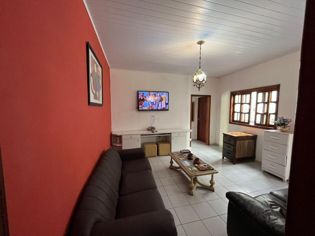 a living room with a couch and a tv at Hostel Alto do Rosario in Vitória