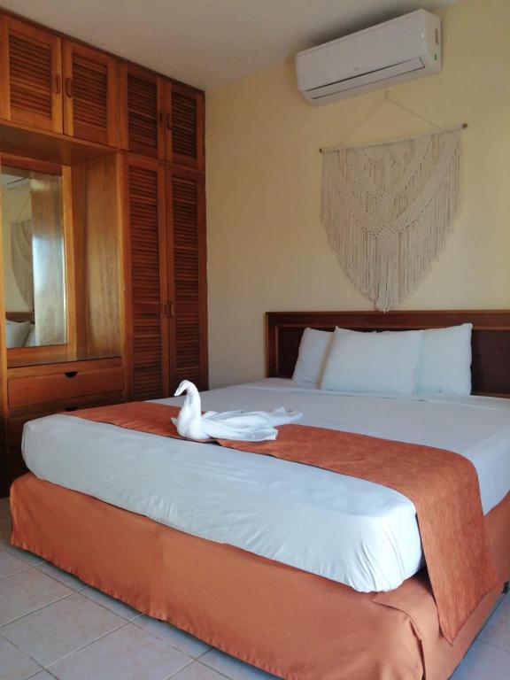 a white swan sitting on top of a bed at Quinta Sea in Playa del Carmen