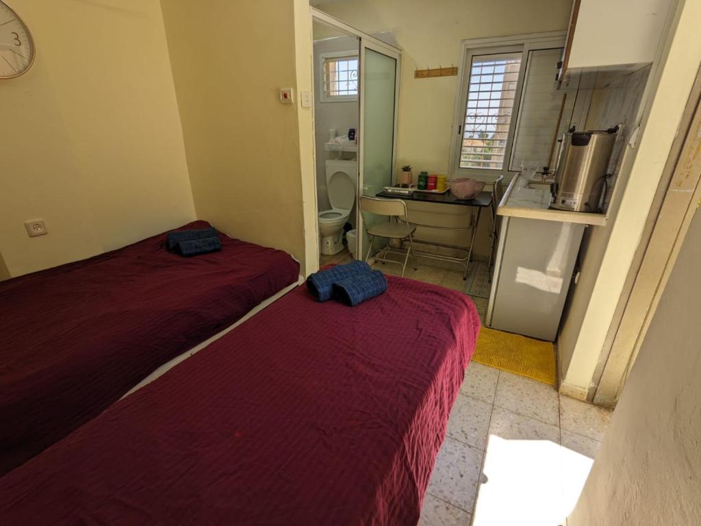 two beds in a small room with a kitchen at חדר אירוח צפתי לזוג in Safed