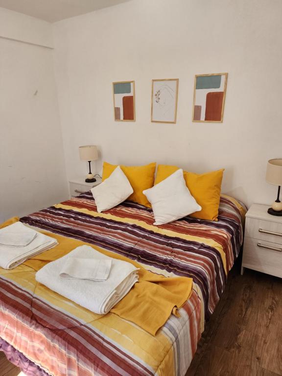 1 dormitorio con 1 cama con toallas en Aires de la Plaza 2 en Salta