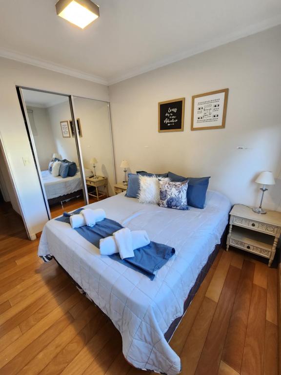 1 dormitorio con 1 cama grande con almohadas azules en Fantástico departamento, en la mejor ubicación. en Salta