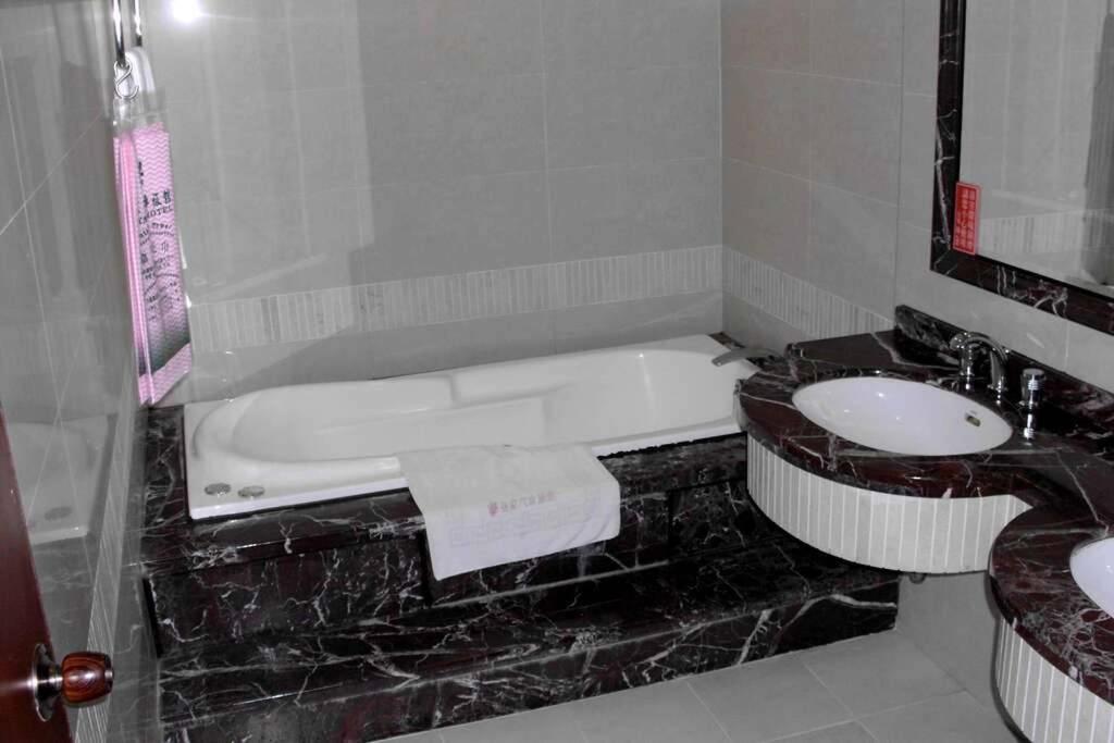 a bathroom with a bath tub and a sink at Jia Yun Business Hotel in Yongkang