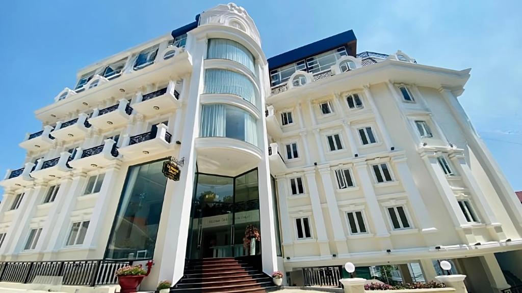 a white building with a staircase in front of it at Le Marais Hotel Dalat in Da Lat